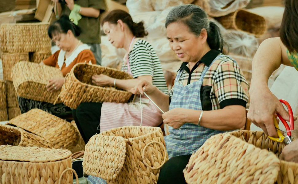 Hundreds of finished handwoven baskets laid out in a factory yard in Bobai County, ready for shipping, with a delivery truck and workers in the background