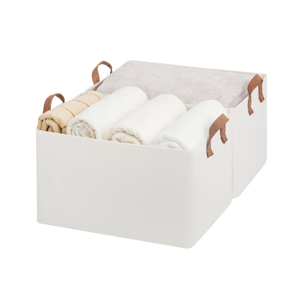 White storage bin with brown PU handles containing folded clothes on a white background