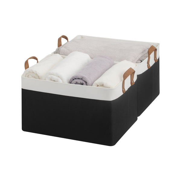 Black storage basket containing folded clothes on a white background