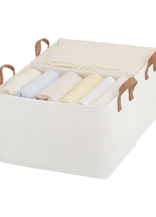 White storage bin with brown handles containing folded clothes on a white background