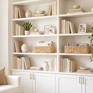 A set of two rectangular water hyacinth baskets on a white bookshelf, featuring natural woven texture.
