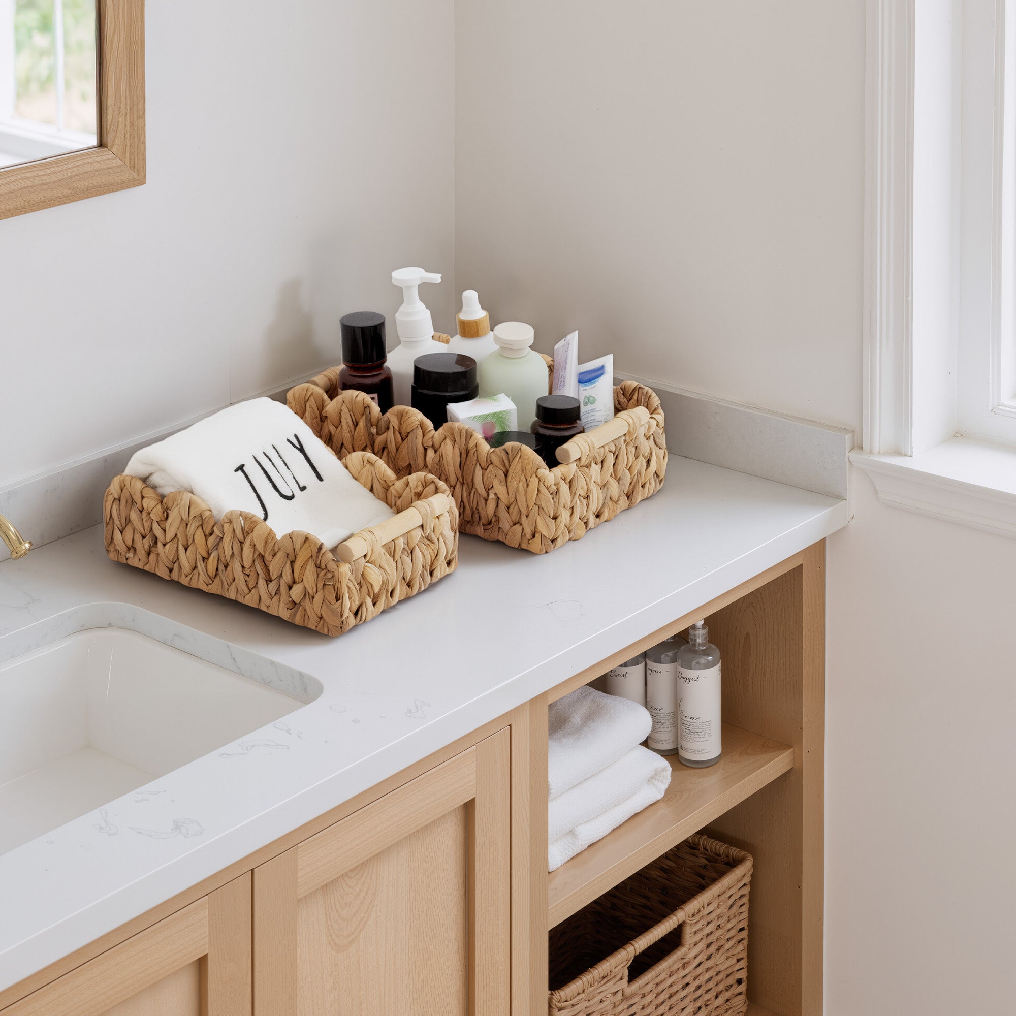 Water Hyacinth Toilet Paper Basket Set, medium and small, handwoven, scalloped edge, on bathroom counter.
