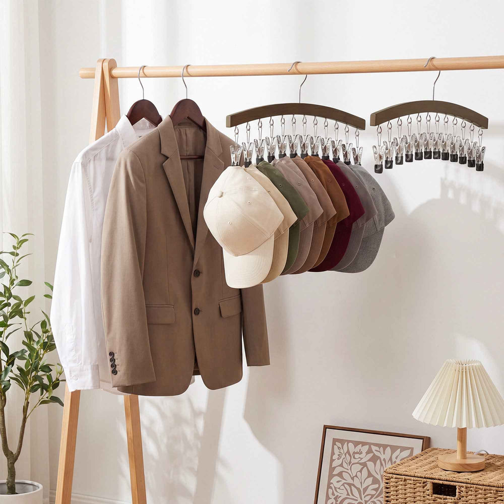 A wooden hat rack with metal clips and a hanger, shown empty at the top and holding multiple baseball caps in different colors at the bottom, on a plain white background.